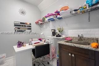 home office featuring sink and vaulted ceiling