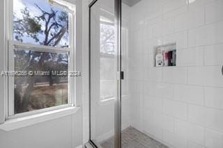 bathroom with a shower with door