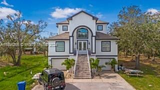 view of front of house with french doors, a front yard, and a garage