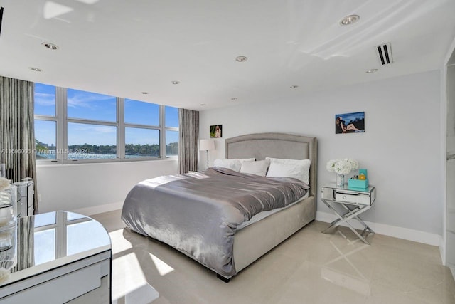 bedroom with a water view and light tile patterned floors