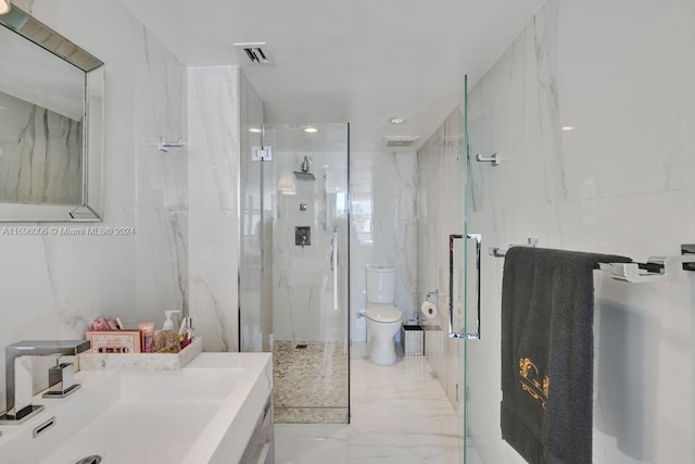 bathroom featuring vanity, a shower with shower door, and toilet