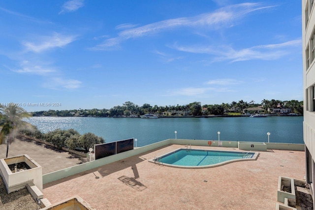 view of swimming pool featuring a water view and a patio