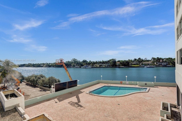 view of pool with a patio area and a water view