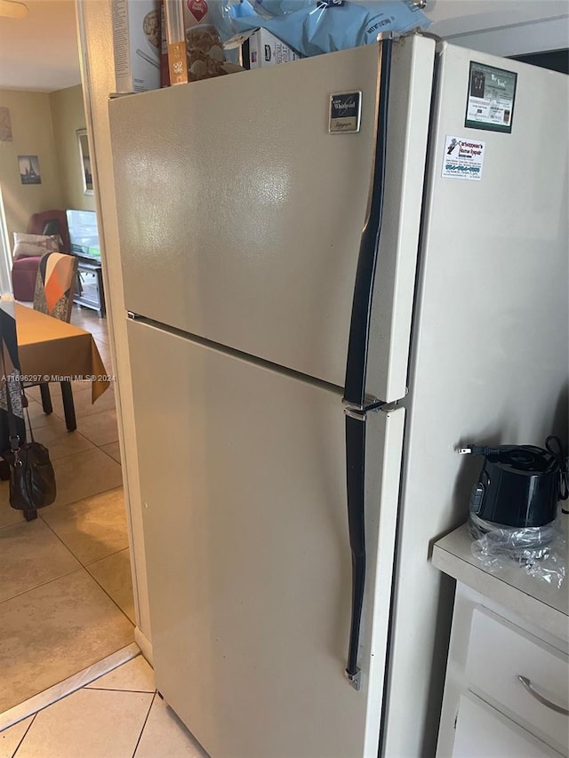 kitchen with light tile patterned floors and stainless steel refrigerator