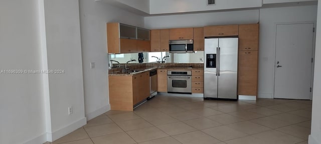 kitchen featuring light tile patterned flooring, stainless steel appliances, and sink