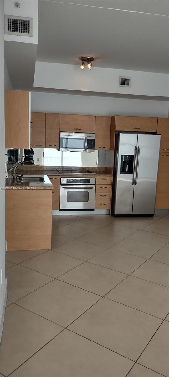 kitchen featuring sink, light tile patterned floors, and appliances with stainless steel finishes