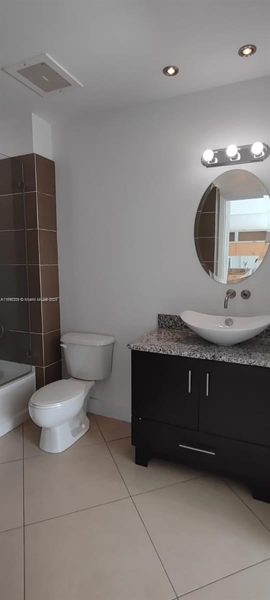 full bathroom with toilet, vanity, tile patterned floors, and shower / washtub combination