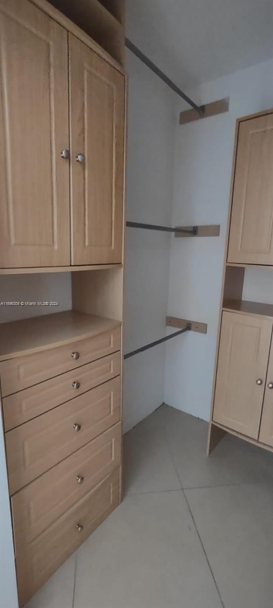 spacious closet featuring light tile patterned floors