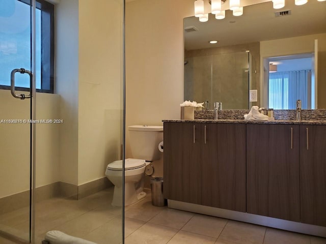 bathroom with tile patterned floors, vanity, toilet, and an enclosed shower