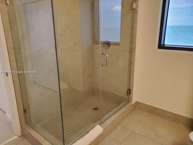 bathroom with tile patterned floors and a shower with door