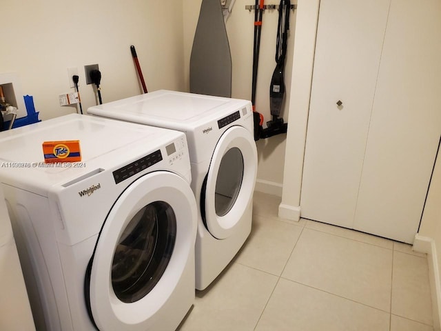 laundry room featuring washing machine and clothes dryer and light tile patterned flooring