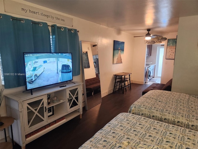 bedroom featuring washing machine and clothes dryer, ceiling fan, and dark hardwood / wood-style floors