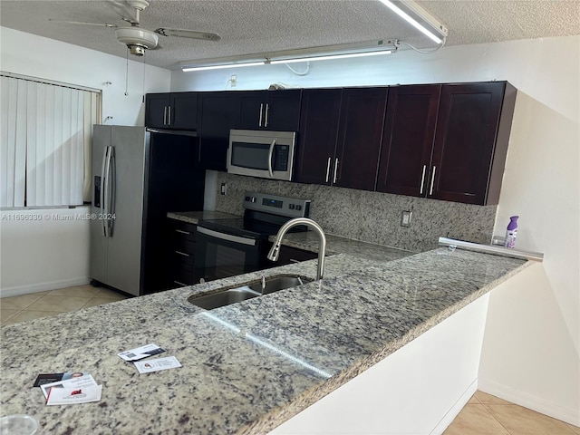 kitchen with sink, ceiling fan, decorative backsplash, a textured ceiling, and stainless steel appliances