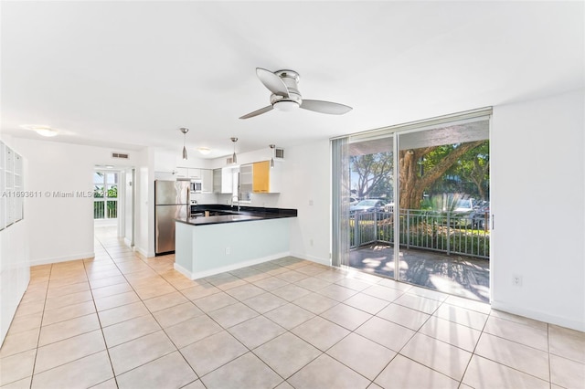 kitchen with ceiling fan, stainless steel appliances, white cabinets, decorative light fixtures, and light tile patterned floors