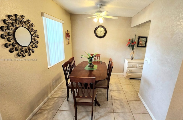 dining space with ceiling fan and light tile patterned flooring