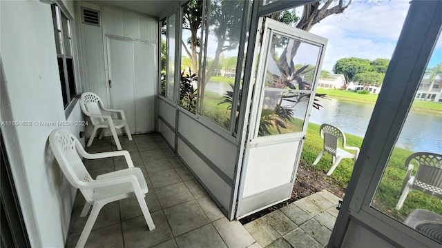 sunroom featuring a healthy amount of sunlight and a water view