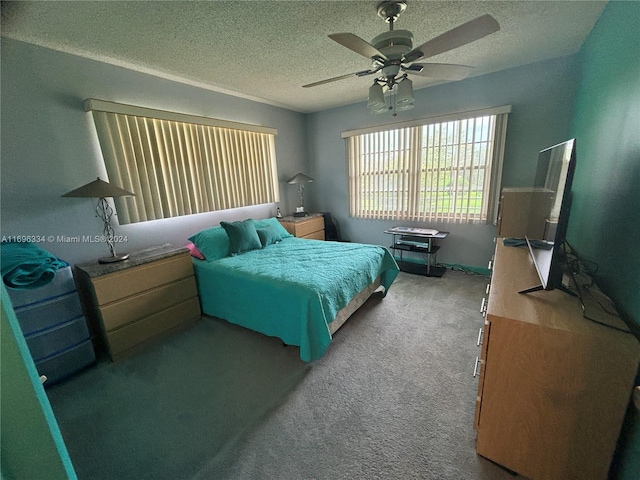 carpeted bedroom with ceiling fan and a textured ceiling