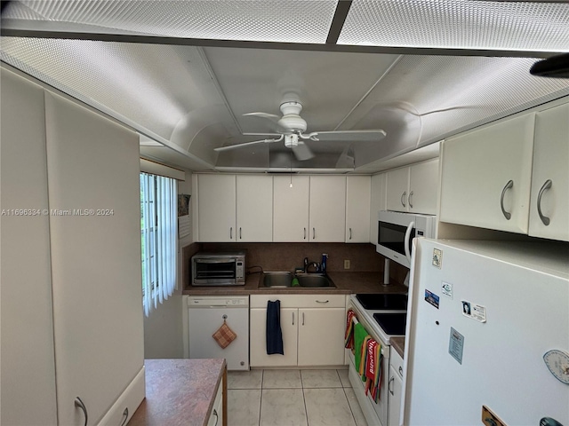 kitchen with white appliances, ceiling fan, sink, light tile patterned floors, and white cabinets