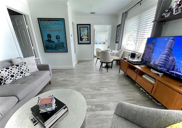 living room featuring light hardwood / wood-style flooring and crown molding