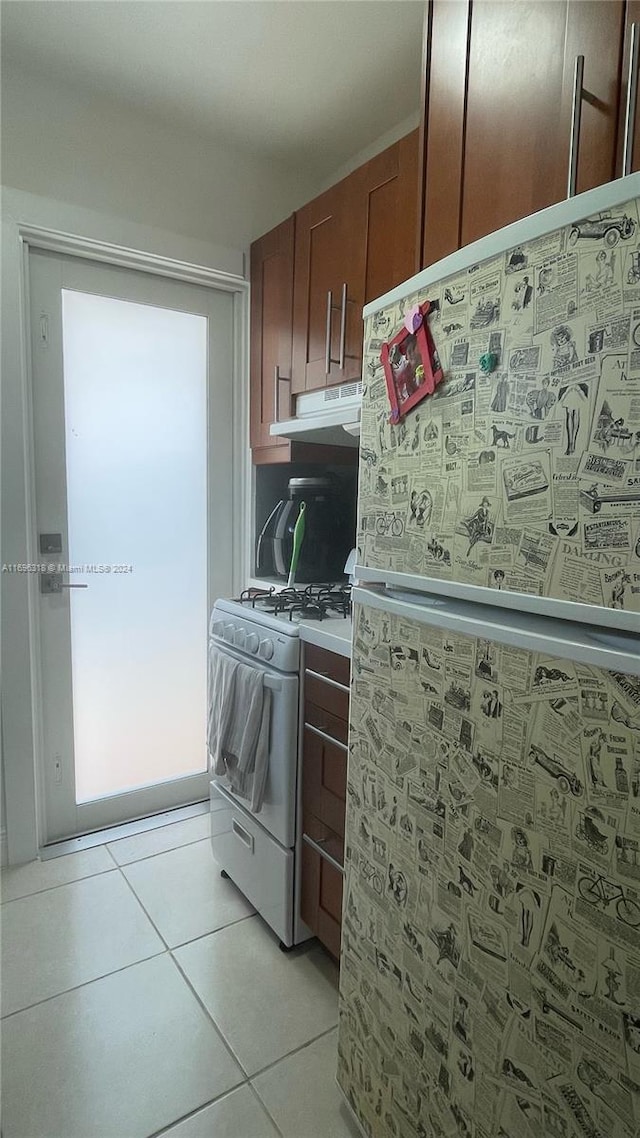 kitchen with light tile patterned floors and white appliances