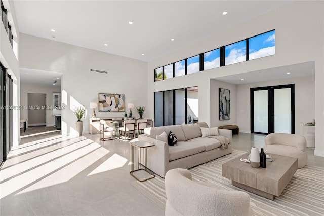 living room featuring a healthy amount of sunlight, a high ceiling, and french doors