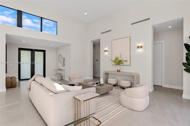 living room with french doors and a towering ceiling