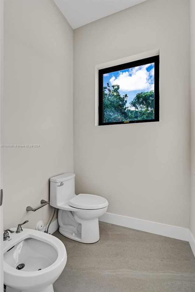 bathroom with tile patterned floors, toilet, and a bidet