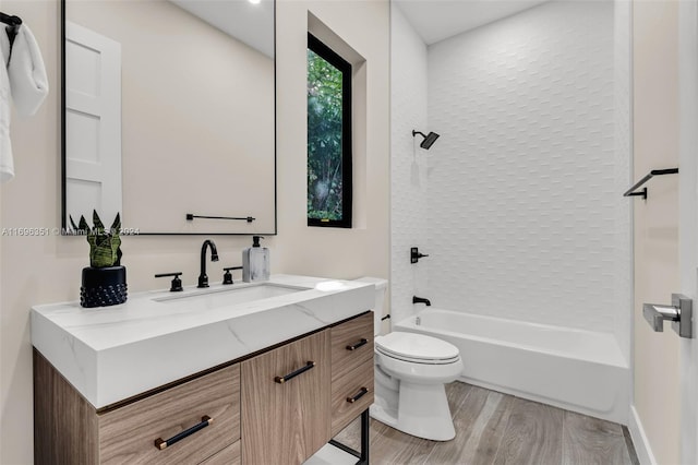 full bathroom featuring hardwood / wood-style floors, vanity, shower / bathtub combination, and toilet