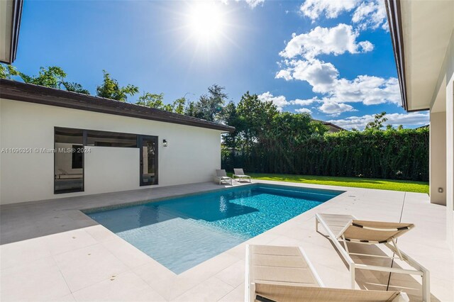 view of swimming pool featuring a yard and a patio