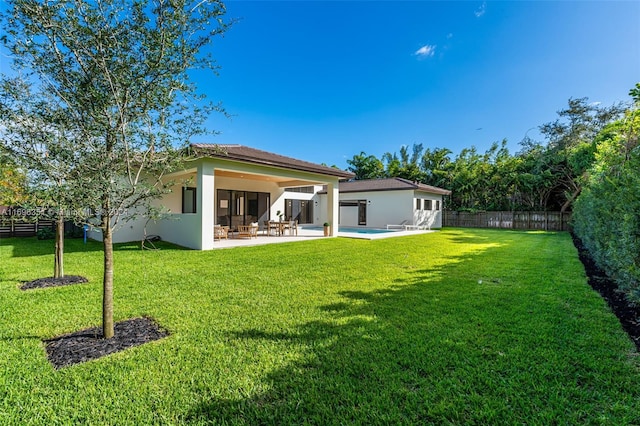 back of house with a lawn and a patio area