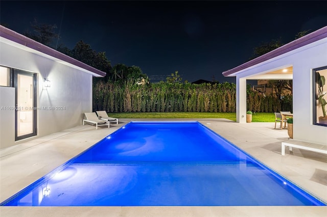 pool at twilight featuring a patio