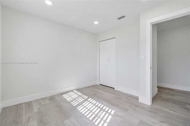 unfurnished bedroom with light hardwood / wood-style flooring and a closet