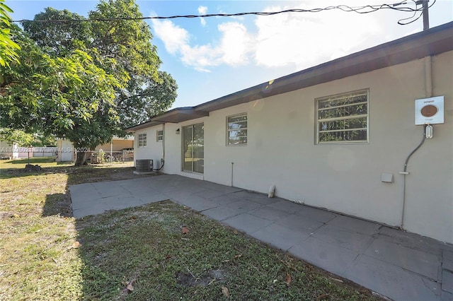 back of property featuring a yard, a patio area, and central air condition unit