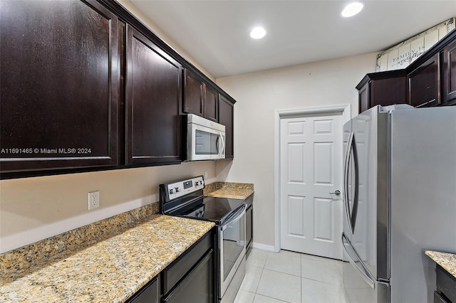 kitchen featuring light tile patterned floors, light stone countertops, dark brown cabinetry, and appliances with stainless steel finishes