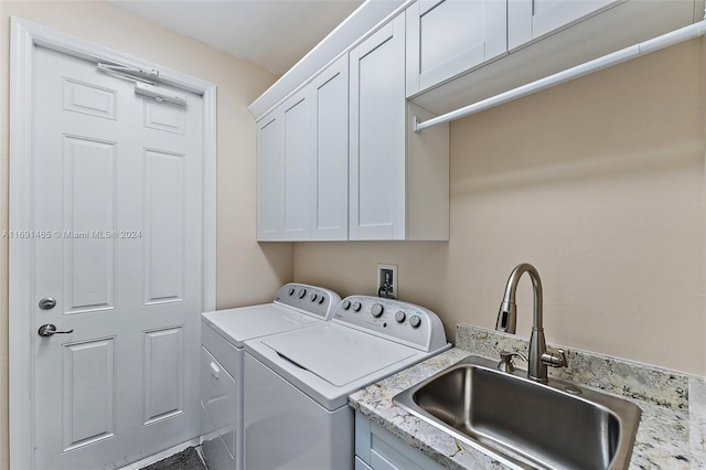 laundry room featuring cabinets, independent washer and dryer, and sink