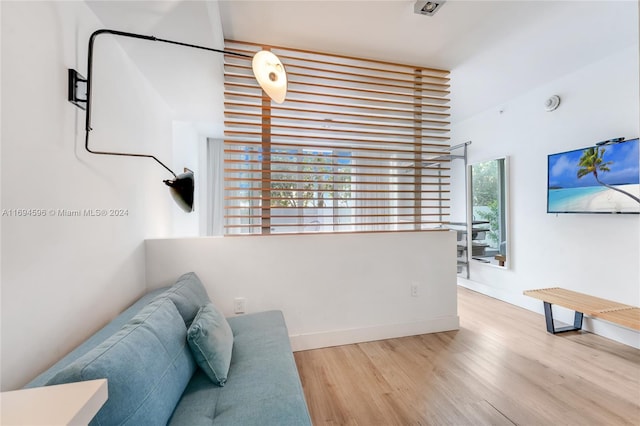 living area with wood-type flooring and a healthy amount of sunlight