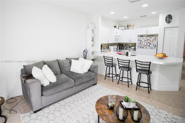 living room featuring light tile patterned floors and sink