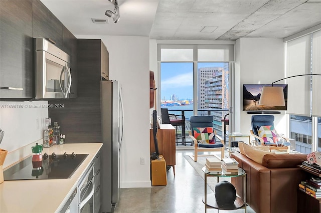 kitchen featuring a wall of windows and appliances with stainless steel finishes