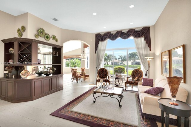 tiled living room with a notable chandelier