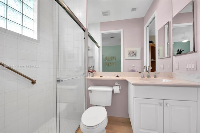 bathroom featuring vanity, toilet, and walk in shower