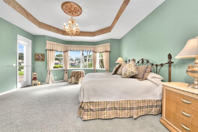 bedroom featuring carpet, a chandelier, and a raised ceiling