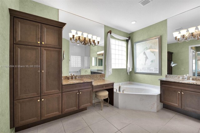 bathroom featuring tile patterned floors, vanity, an inviting chandelier, and a bathing tub