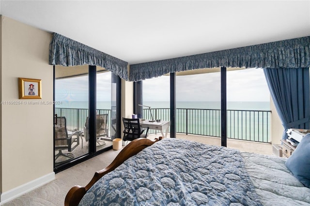 bedroom with carpet, a water view, and access to exterior