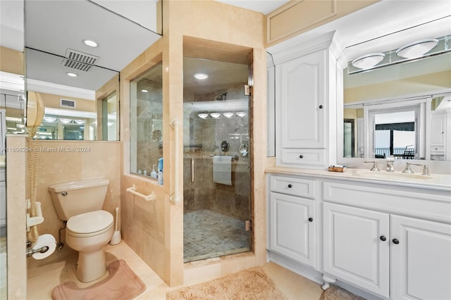 bathroom featuring tile patterned floors, a shower with door, vanity, and toilet