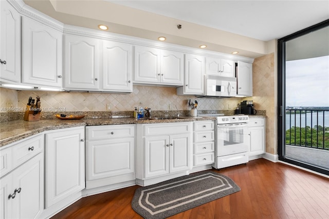 kitchen with decorative backsplash, white cabinetry, dark hardwood / wood-style floors, and white appliances