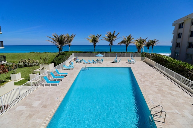 view of swimming pool with a patio and a water view