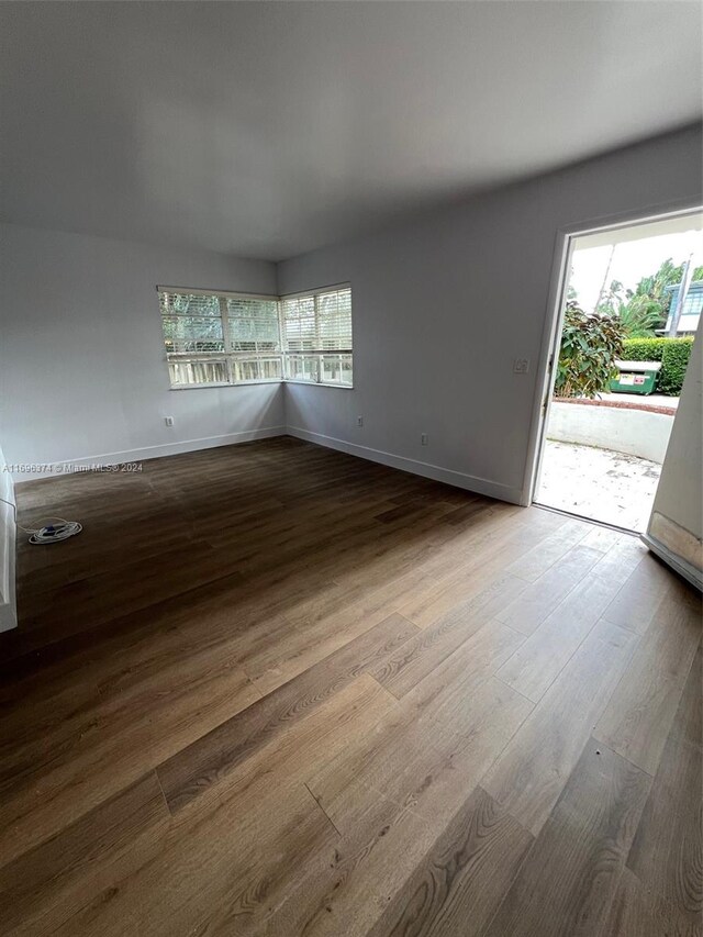 spare room with plenty of natural light and wood-type flooring