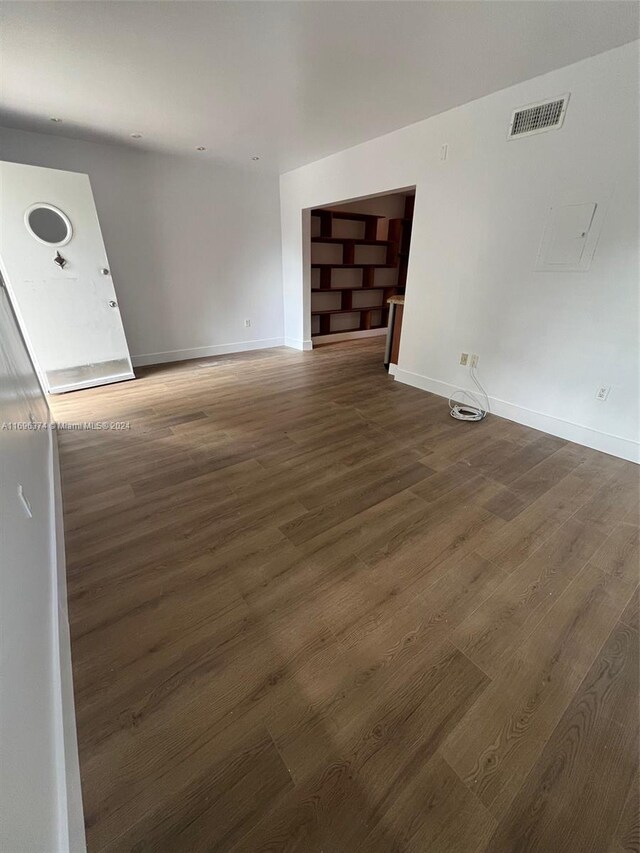 unfurnished living room with dark wood-type flooring