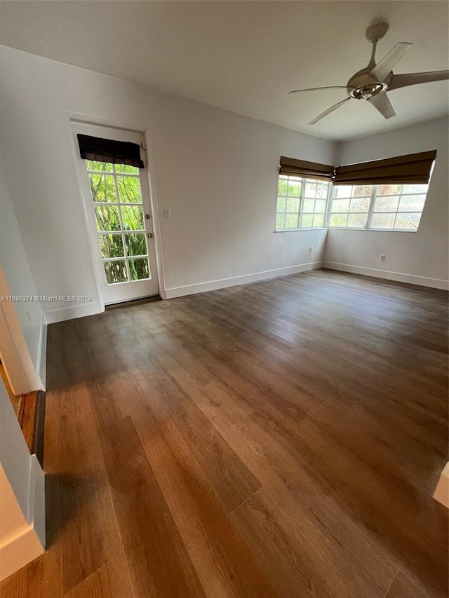 unfurnished room featuring ceiling fan and dark wood-type flooring