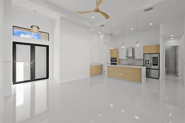 kitchen featuring pendant lighting, stainless steel appliances, ceiling fan, and a large island